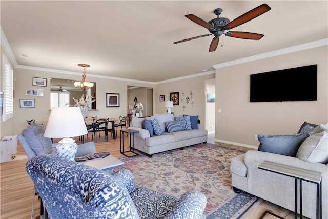living area featuring ornamental molding, wood finished floors, and ceiling fan with notable chandelier