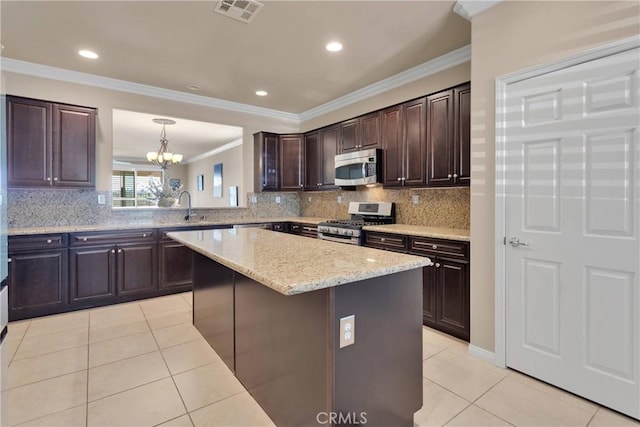kitchen with dark brown cabinets, light tile patterned floors, stainless steel appliances, ornamental molding, and visible vents