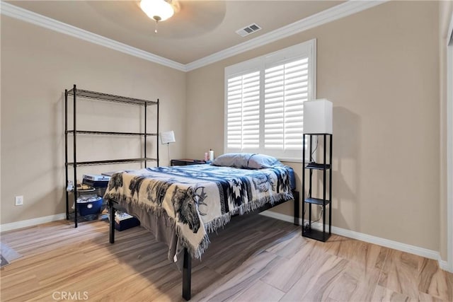 bedroom with baseboards, ornamental molding, wood finished floors, and visible vents