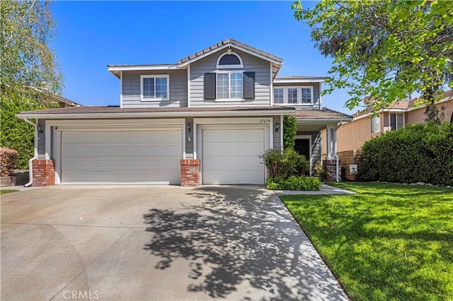 traditional home with a front yard, concrete driveway, a garage, and brick siding