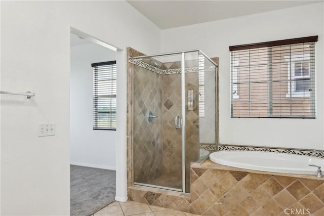bathroom featuring a shower stall, a garden tub, and tile patterned flooring