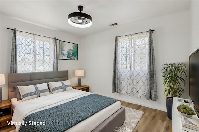 bedroom featuring wood finished floors and visible vents