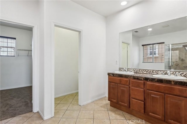 full bath with tile patterned floors, a sink, a shower stall, and double vanity