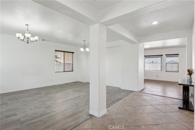 interior space with baseboards, a notable chandelier, and a healthy amount of sunlight