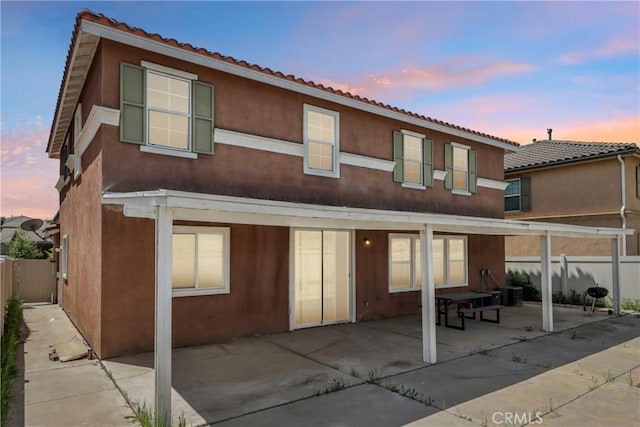townhome / multi-family property with stucco siding, fence, and a patio