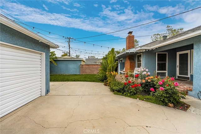 view of patio / terrace with fence and a garage