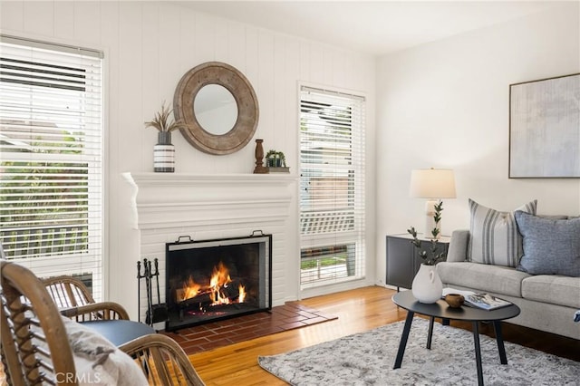 living area featuring a fireplace with flush hearth and wood finished floors