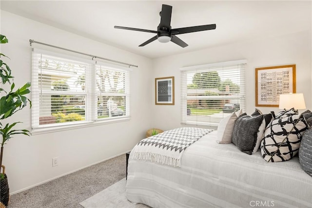 carpeted bedroom featuring baseboards and ceiling fan