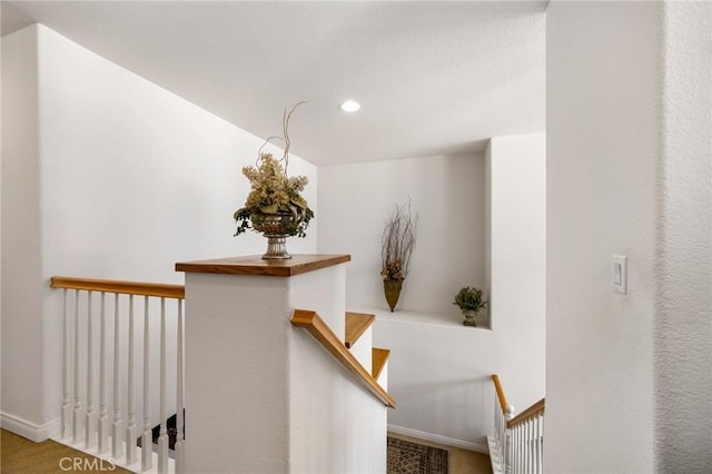 corridor with recessed lighting, baseboards, and an upstairs landing