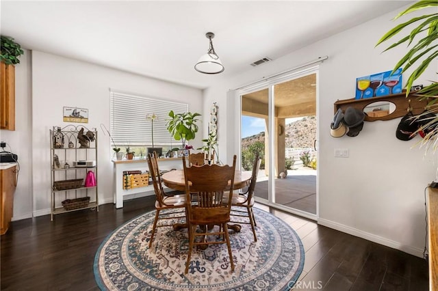 dining space featuring baseboards, visible vents, and dark wood-style floors