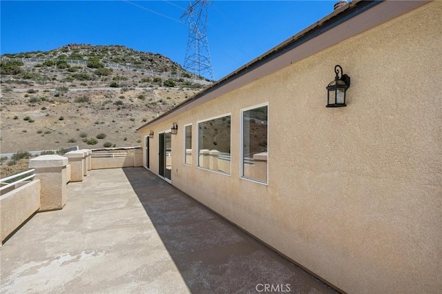 view of home's exterior featuring a balcony, a mountain view, and stucco siding