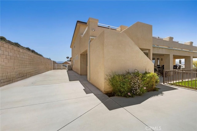 view of side of home with fence and stucco siding