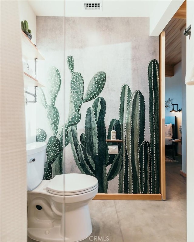 bathroom with toilet and concrete flooring