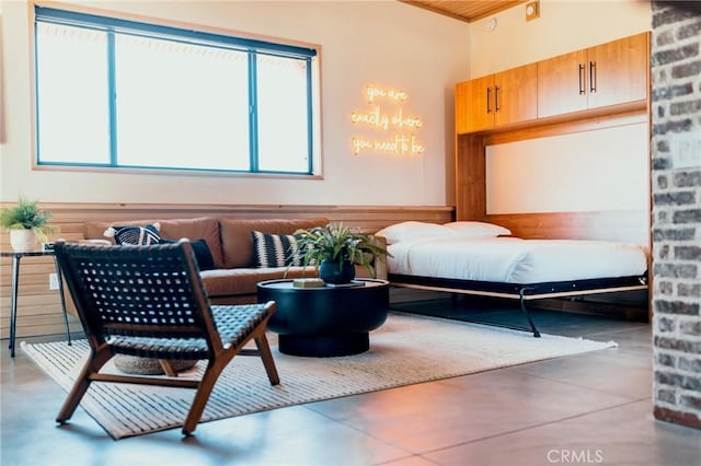bedroom featuring concrete floors and multiple windows