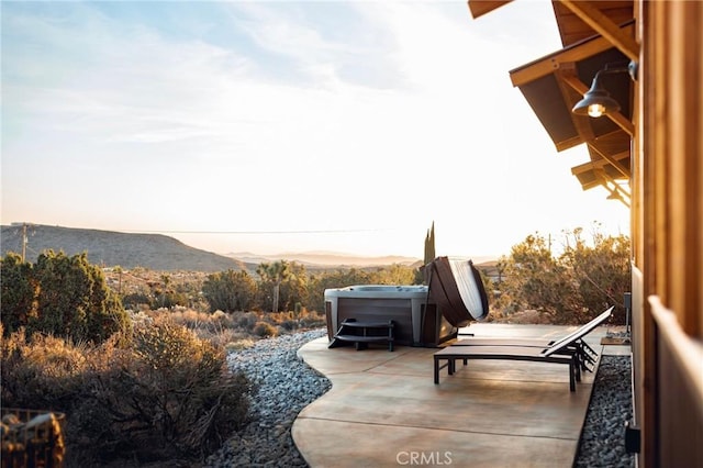 patio terrace at dusk featuring a mountain view