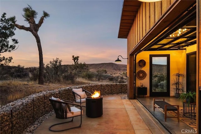 view of patio featuring an outdoor fire pit and a mountain view