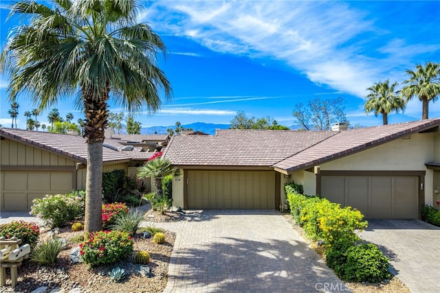 283 Wild Horse Dr, Palm Desert, CA 92211 - ranch-style house with an attached garage, a tiled roof, decorative driveway, and stucco siding