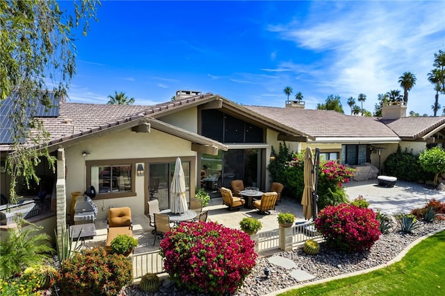 283 Wild Horse Dr, Palm Desert, CA 92211 - back of house featuring a tile roof, a chimney, a patio, and stucco siding
