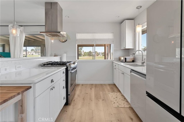 kitchen featuring white cabinets, appliances with stainless steel finishes, a sink, island exhaust hood, and light wood-type flooring