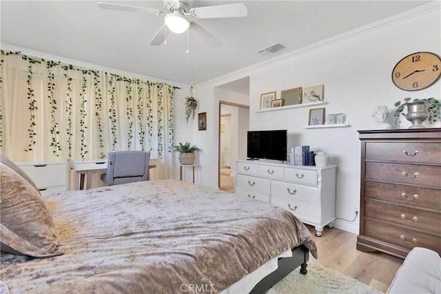 bedroom with visible vents, a ceiling fan, crown molding, and wood finished floors