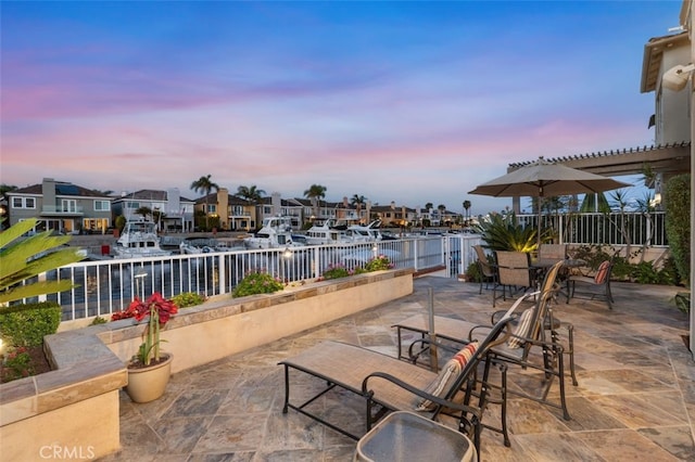 view of patio / terrace featuring a residential view, a pergola, a water view, and fence