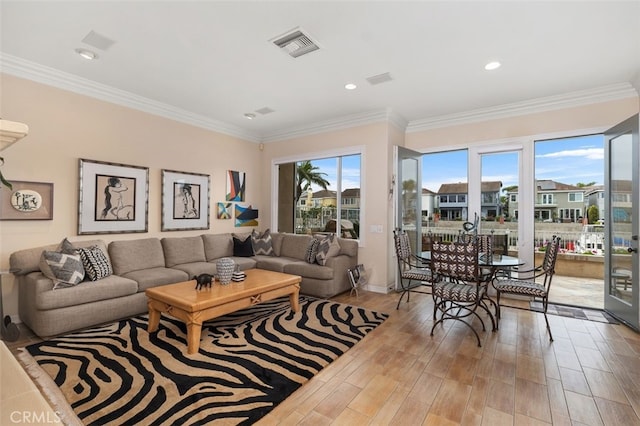 living room featuring visible vents, baseboards, recessed lighting, ornamental molding, and wood finished floors