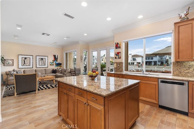 kitchen with visible vents, stainless steel dishwasher, light wood finished floors, and brown cabinetry