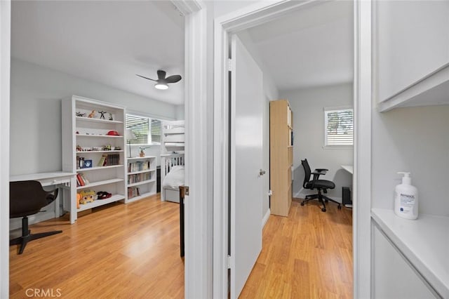 hallway with light wood-type flooring and plenty of natural light