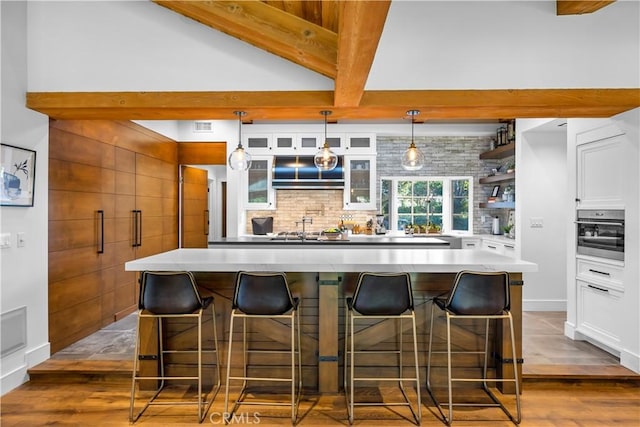14 Chuckwagon Rd, Rolling Hills, CA 90274 - kitchen with dark wood-style flooring, a kitchen breakfast bar, stainless steel oven, and white cabinets