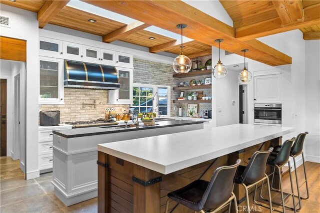 14 Chuckwagon Rd, Rolling Hills, CA 90274 - kitchen featuring stainless steel appliances, wood ceiling, range hood, and a center island with sink
