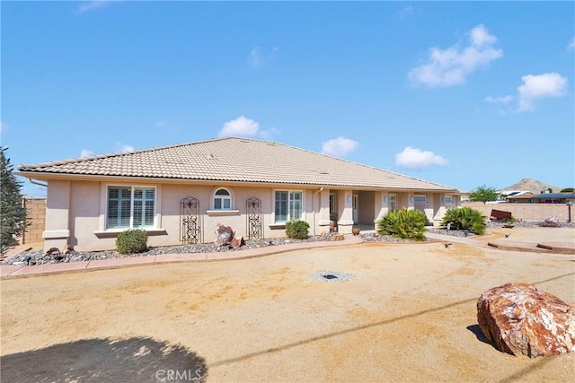 single story home with a tiled roof and stucco siding