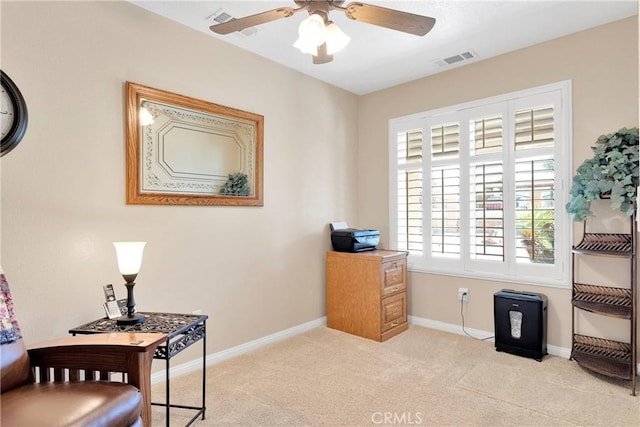 interior space featuring light carpet, baseboards, visible vents, and ceiling fan