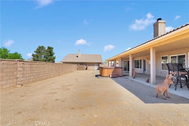 view of yard with a fenced backyard, a hot tub, and a patio