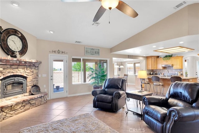 living room featuring visible vents, a fireplace, ceiling fan, and light tile patterned flooring