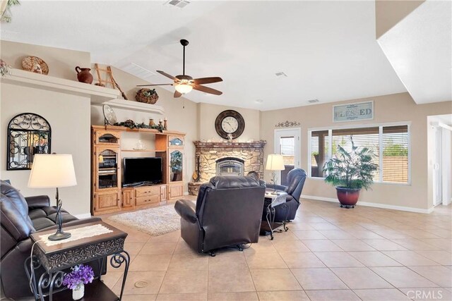 living room featuring lofted ceiling, light tile patterned floors, baseboards, a fireplace, and ceiling fan