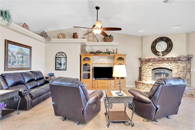 living area featuring lofted ceiling, a stone fireplace, a ceiling fan, and light tile patterned floors