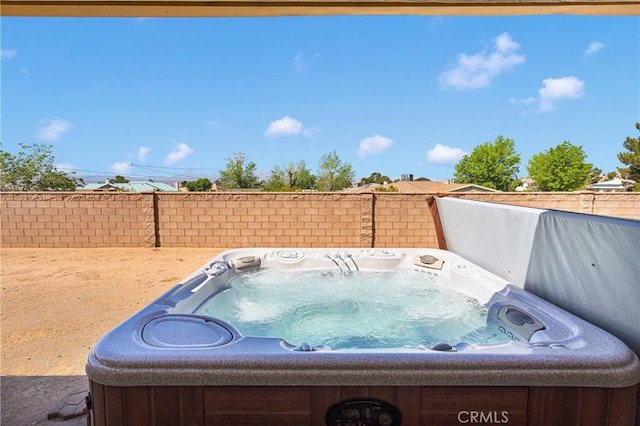 exterior space with fence and a hot tub