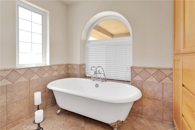 full bath with tile walls, a wainscoted wall, and a freestanding tub