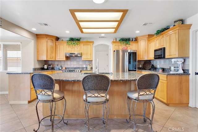 kitchen featuring a sink, dark stone countertops, smart refrigerator, black microwave, and under cabinet range hood