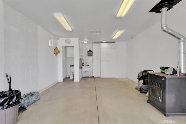 garage featuring a wood stove and visible vents