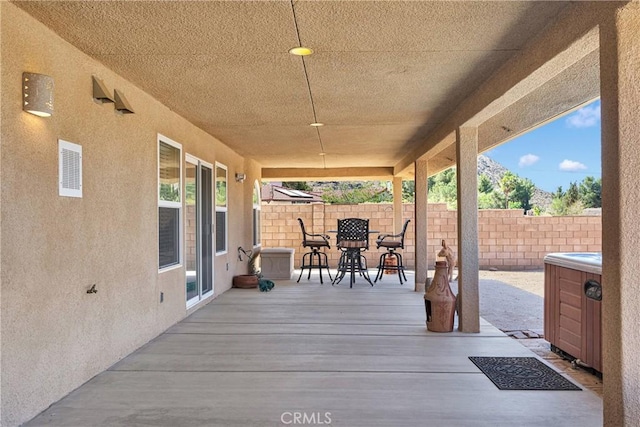 wooden terrace with fence, outdoor dining area, and a patio