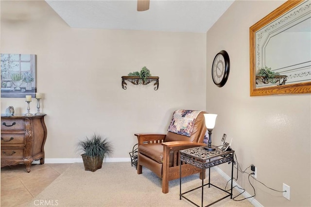sitting room with baseboards, ceiling fan, and light tile patterned floors
