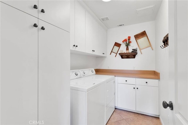 clothes washing area with light tile patterned flooring, cabinet space, washer and clothes dryer, and visible vents