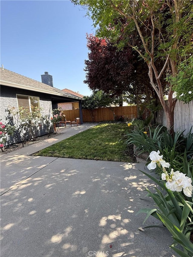 view of yard with fence and a patio