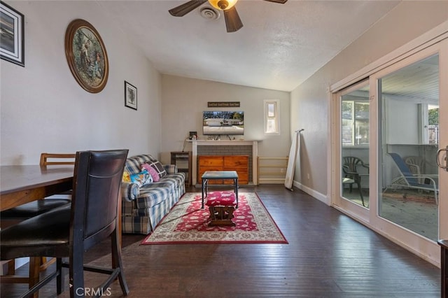 living area featuring wood-type flooring, vaulted ceiling, a ceiling fan, and baseboards
