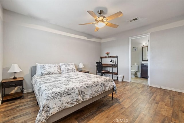 bedroom with baseboards, wood finished floors, and visible vents