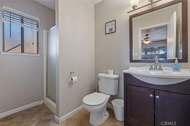 bathroom featuring tile patterned floors, toilet, baseboards, a shower stall, and vanity