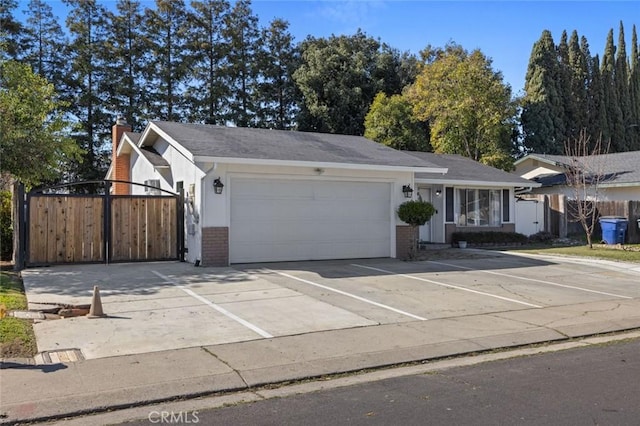 view of front of house with an attached garage, fence, brick siding, and a chimney
