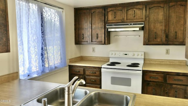 kitchen with under cabinet range hood, white electric stove, light countertops, and a sink