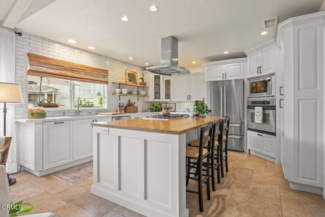 614 Crestview Dr, Ojai, CA 93023 - kitchen featuring appliances with stainless steel finishes, island range hood, a sink, white cabinetry, and recessed lighting